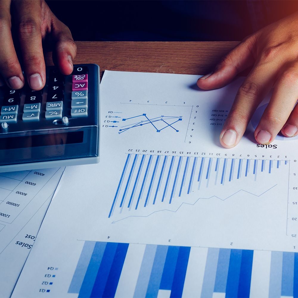 Selective focus hand asian business man is calculating finance and accounting with growth up paper chart on wood table in home office.Pen calculator graph document on desk.economy,saving,financial.